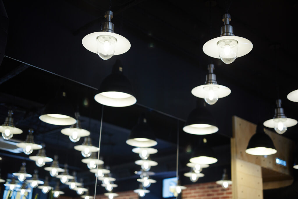 Part of ceiling of cafe with rows of glowing lamps that may be used as background